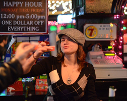 Summary graphic: A bartender holds up a plastic shot glass to the camera, while multiple arms enter the frame holding up shots toward her.