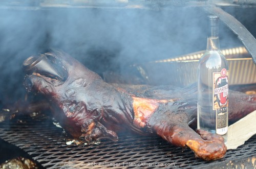 Whole hog in barrel smoker with vodka bottle