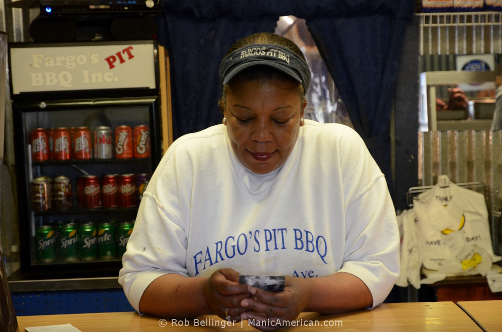 Belinda of Fargo's Pit BBQ holding a Manic Card.