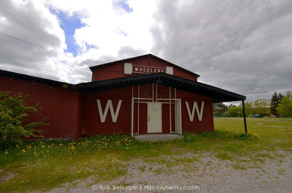 A red wooden country dance hall called Wheelers under cloud and sun. Outside Stephenville, Newfoundland.