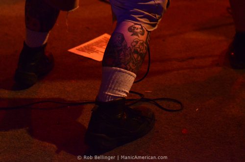 ace of spades tattoo on the calf of a musician onstage