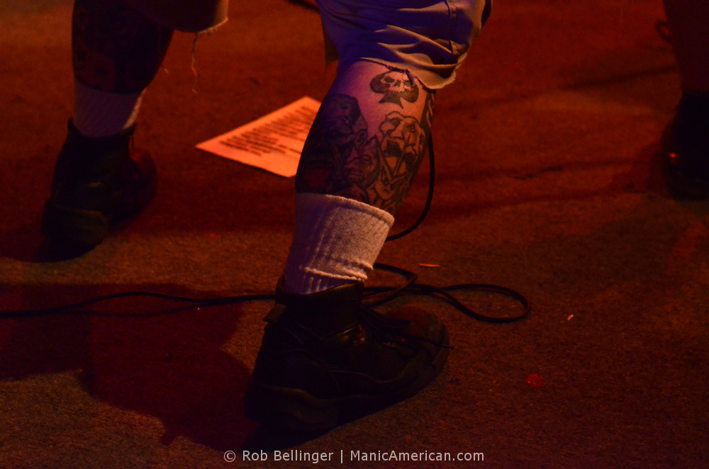 ace of spades tattoo on the calf of a musician onstage