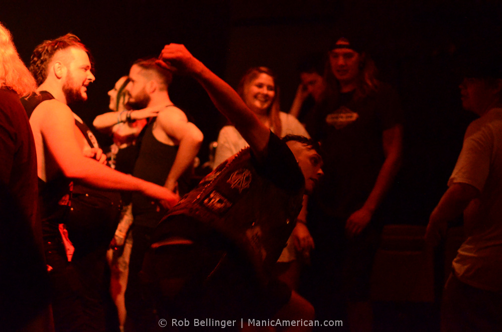 a mosher swinging his fists in a circle pit