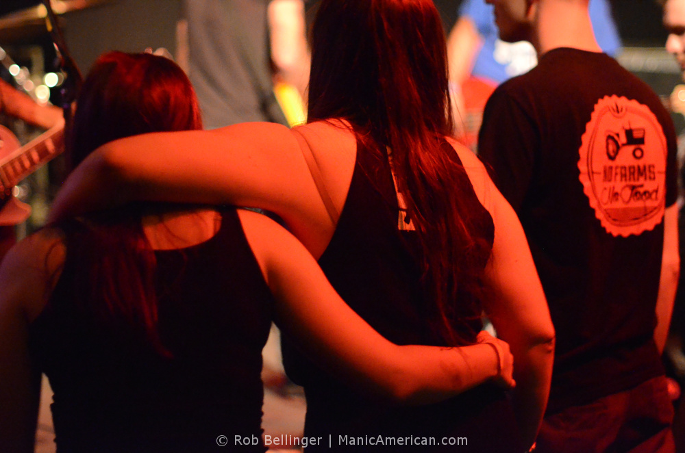 women at a punk show standing arm in arm