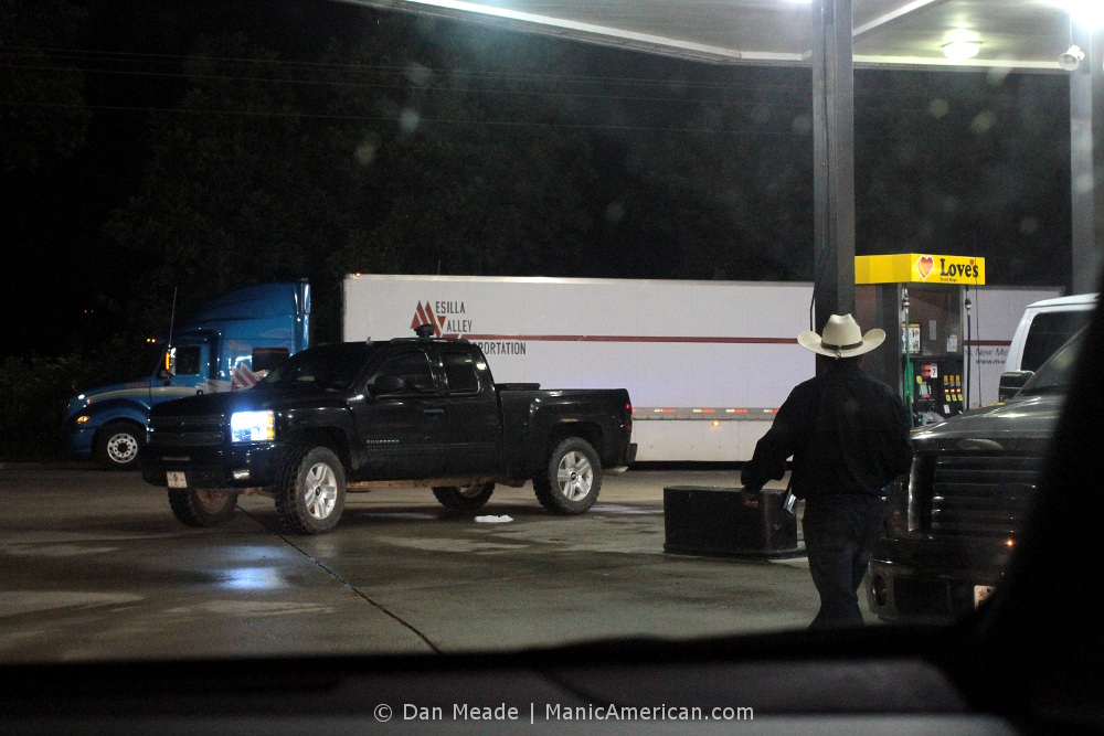 a cowboy exists his car