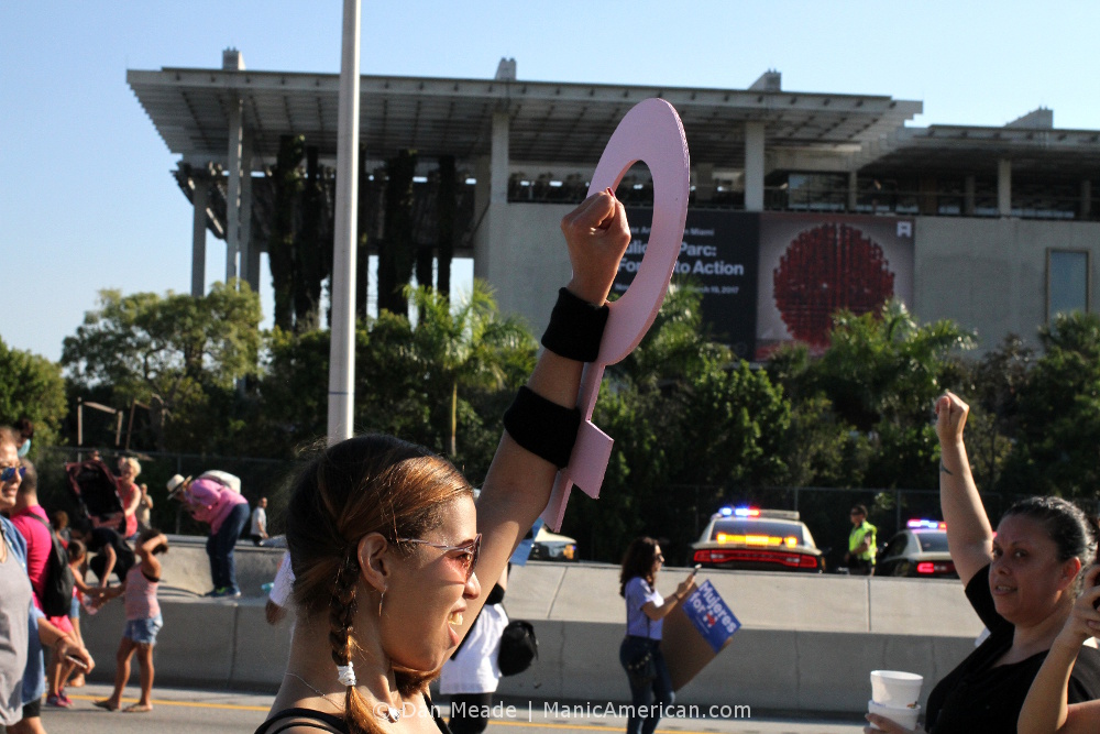 A woman hold up an arm-mounted sign