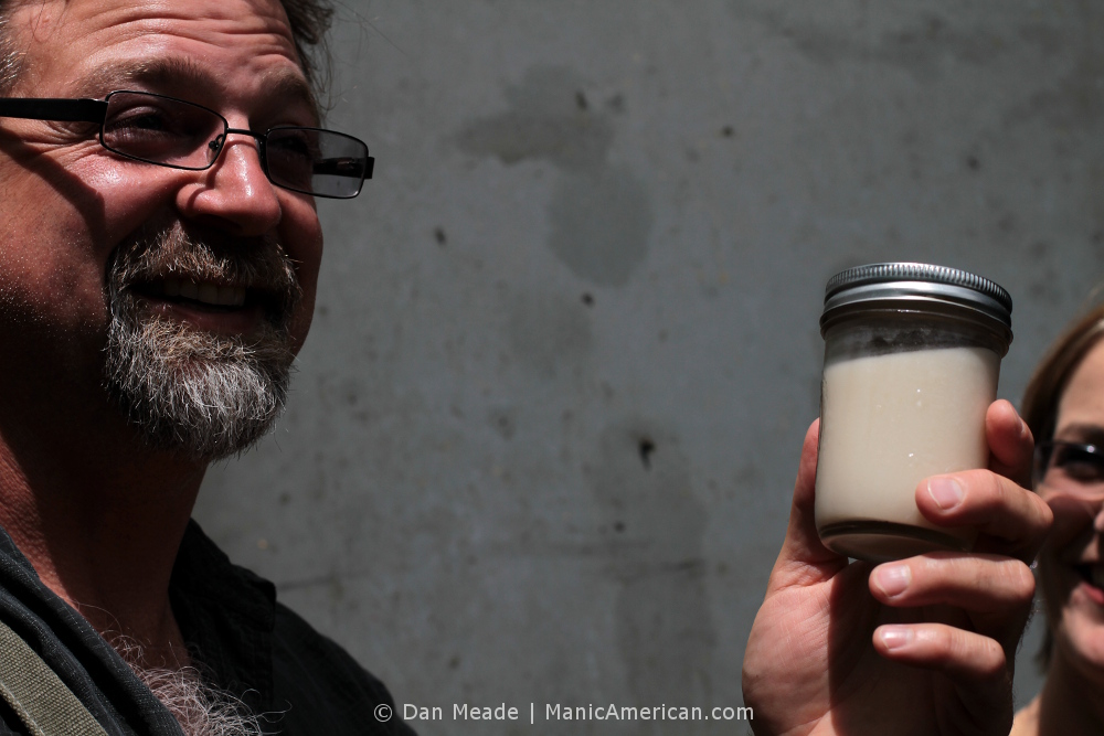 Wes Berry holds up a jar of homemade Korean-style rice wine.