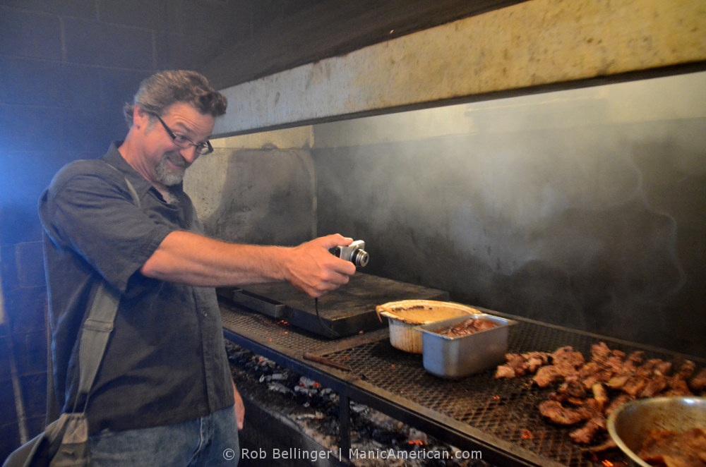 Professor Wes Berry in the Smokey Pig cookhouse, using a point-and-shoot camera to photograph the grill