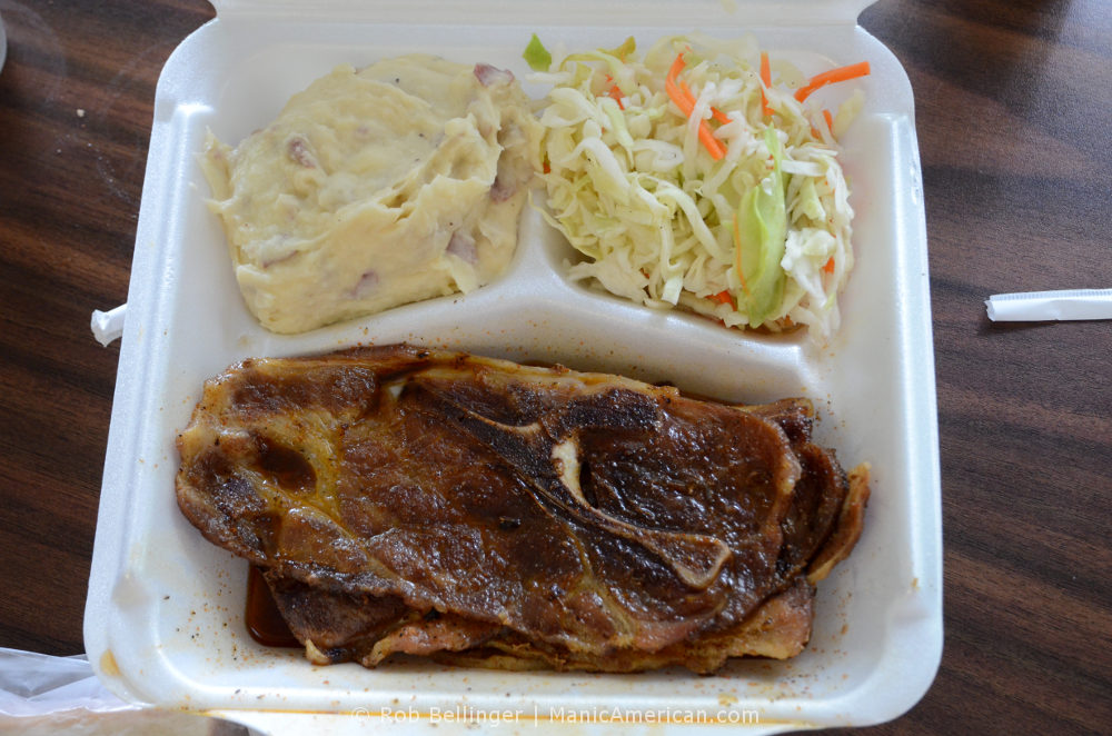 A styrofoam tray containing cooked Kentucky barbecue: pork shoulder, cole slaw, and potato salad