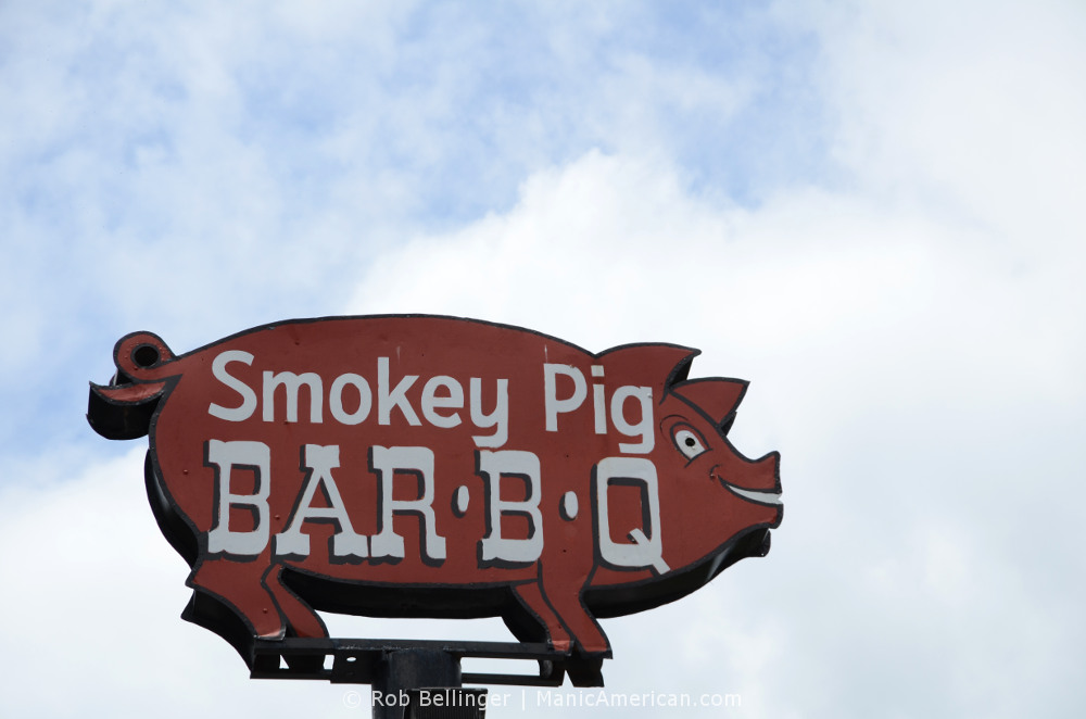 A metal sign in the shape of a pig reads Smokey Pig Bar-B-Q