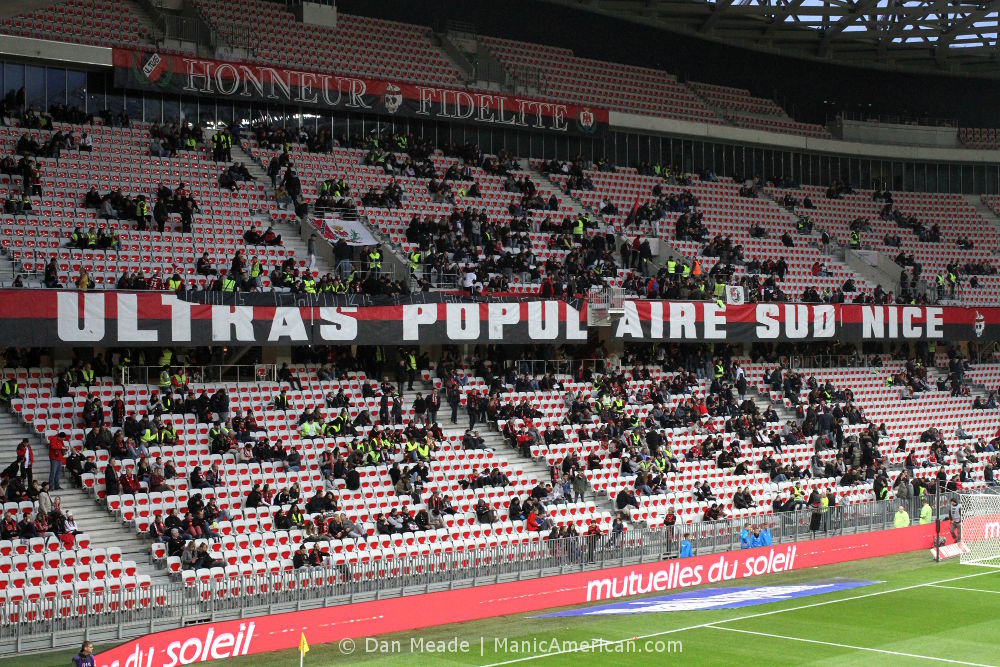 The "ultras" section of OGC "ultras" fan wear giletes jaunes at Allianz Riviera filling up with fans wearing gilets jaunes.