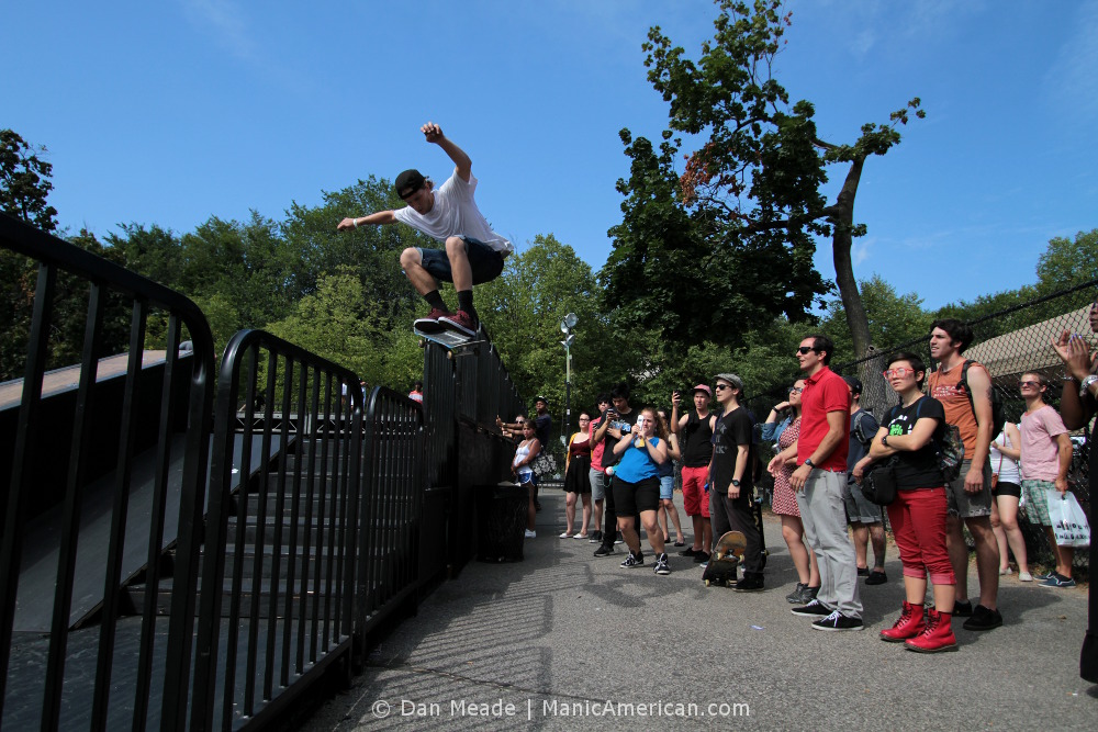 A skater jumps over a fence.