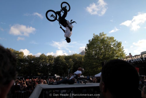 One BMXer backflips over another.