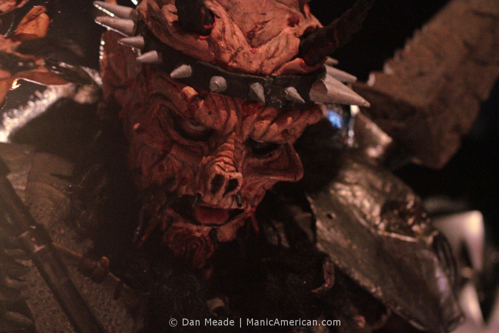 A close-up photo of GWAR’s David Brockie as David Brockie as Oderus Urungus. Brockie looks through his Oderus mask directly at the camera.