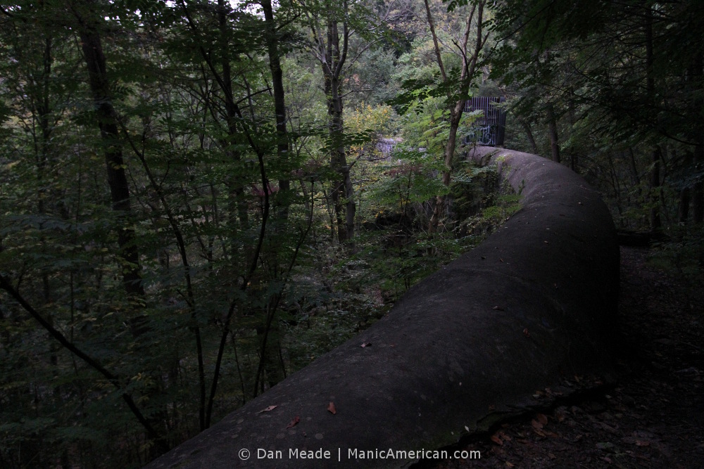 A stone aqueduct winds through trees