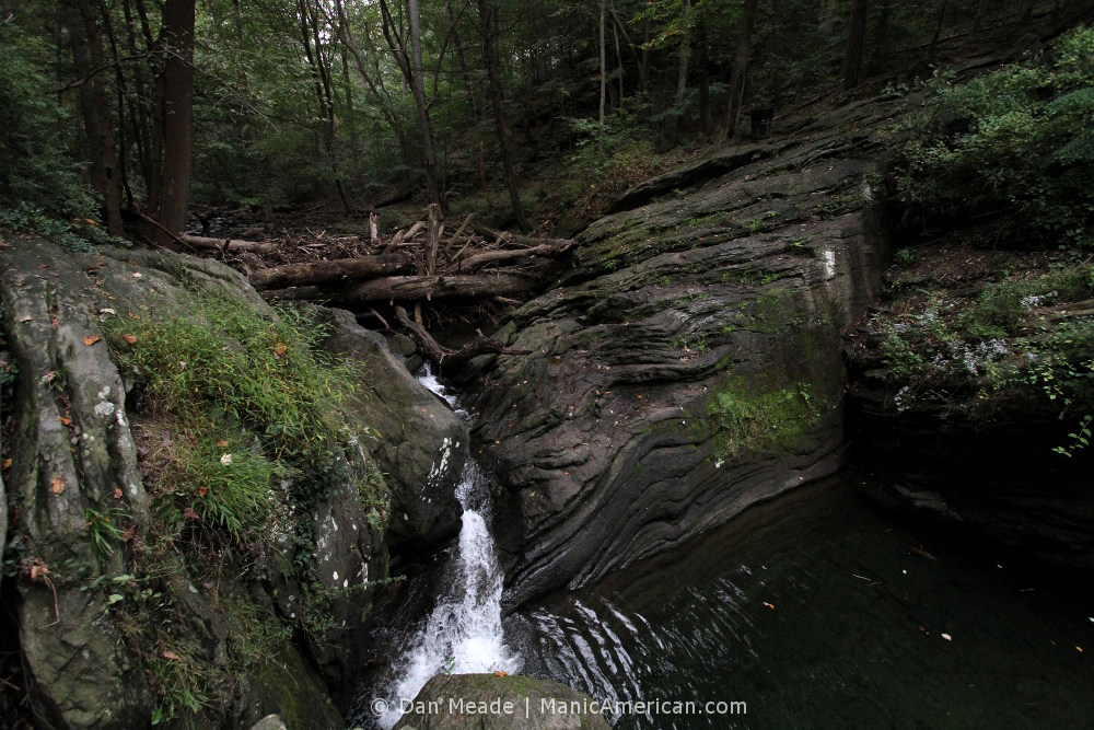 white water rushes through rocks and into the pool