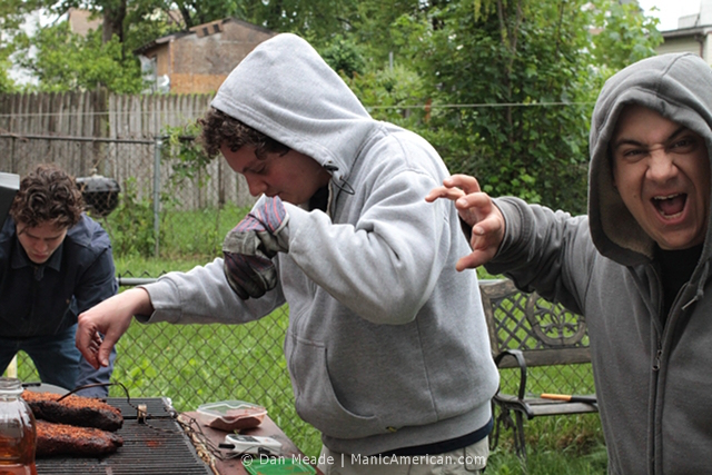 Friends gather around a smoker.