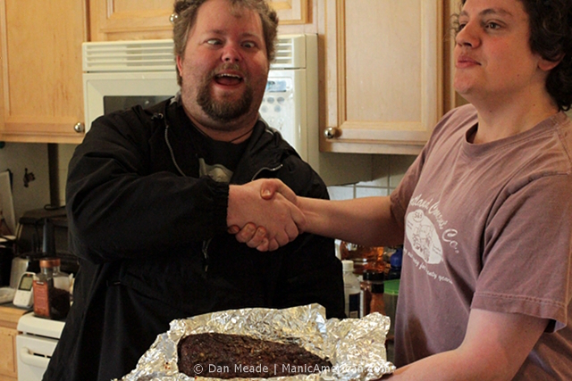 Friends shake hands over a gifted brisket.