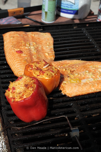 Salmon and peppers within a smoker.