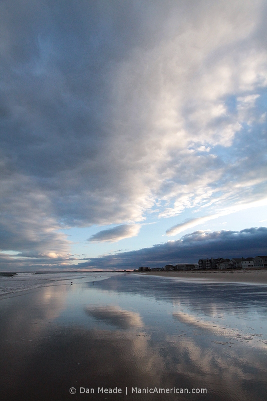A partly cloudy sky reflected over the shore of Old Orchard Beach.