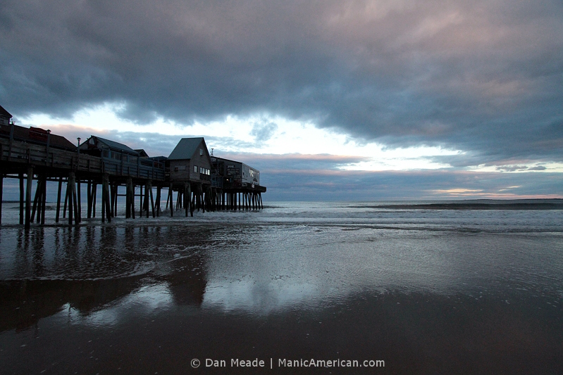A pier reflected over the shore of Old Orchard Beach.