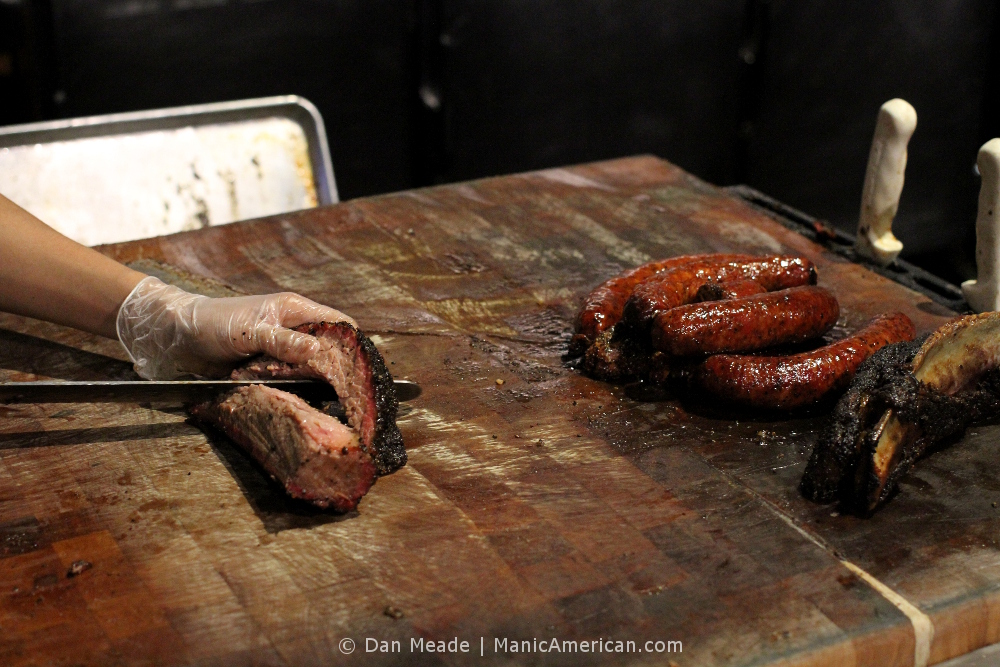 A worker slices off a piece of brisket at Terry Black's Barbecue.