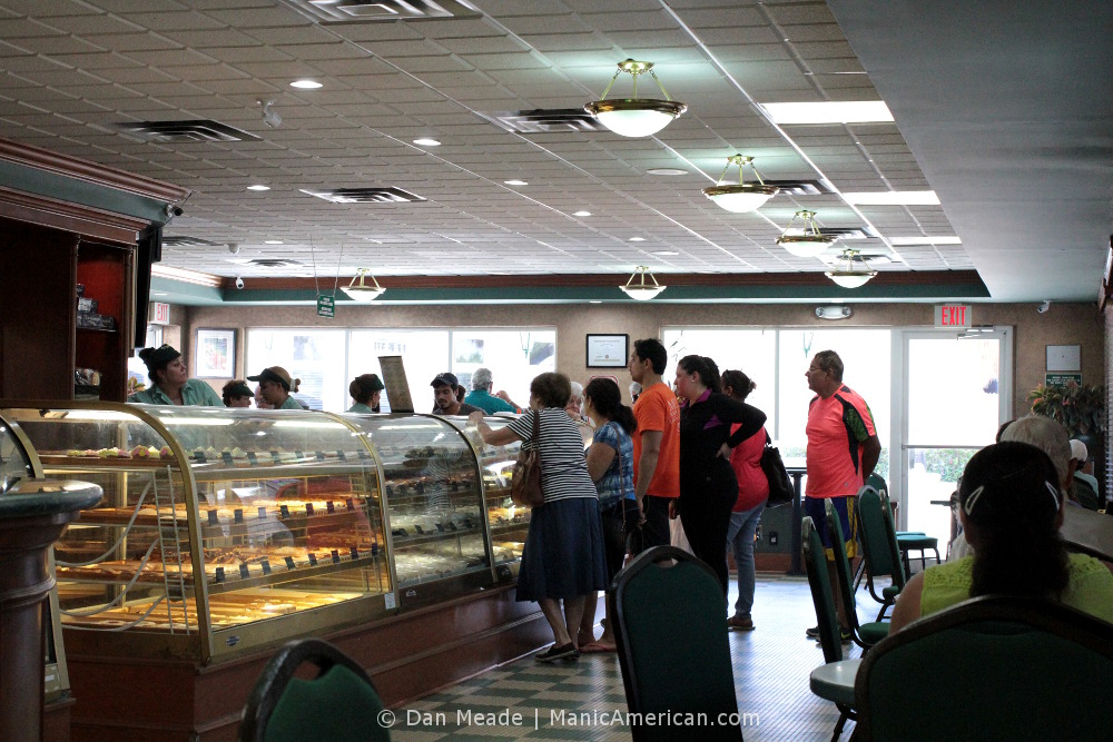 People gathered around Versailles’s lunch and pastry counter.