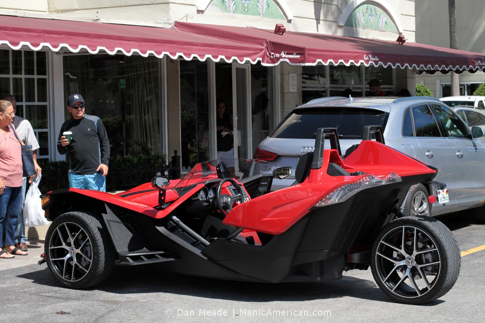 A cherry red Polaris Slingshot parked in Versailles's parking lot.