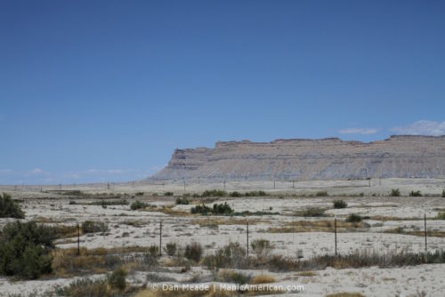 A grey landscape leading to a series of grey buttes.