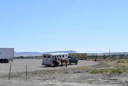 A horse trailer amid a sparse landscape.