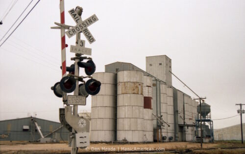The Williamson County Grain silos beside a railroad crossing.