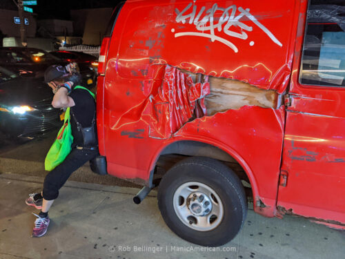 a young man leans against a graffitied red van with extensive damage in rockaway beach