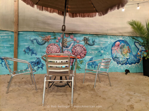 chair and tables on sand covered dining area at mara's in rockaway beach
