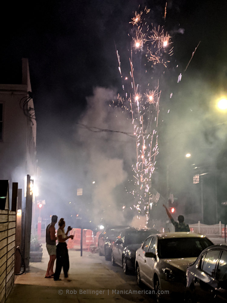 revelers celebrate in the streets of rockaway beach as fireworks explode
