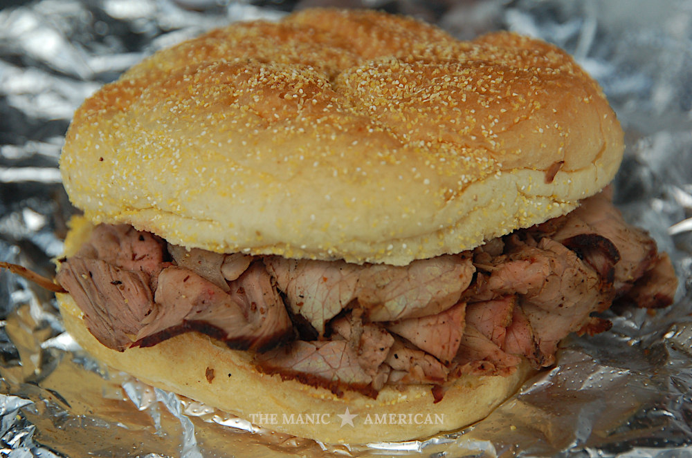 Sliced beef on a Kaiser roll, sitting atop aluminum foil